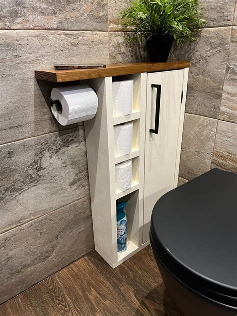 A Toilet Paper Dispenser Next To A Wooden Shelf