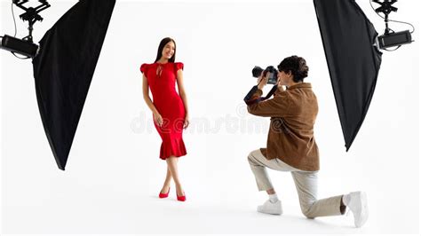 Fotógrafo Masculino Capturando a Una Hermosa Modelo Con Vestido Rojo