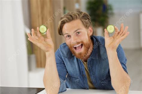 Happy Man Holds Cucumber In Front Of Camera Photo Background And