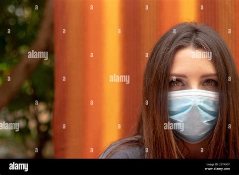 Attractive Brunette Wearing A Surgical Face Mask Looking Confidently