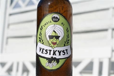 A Beer Bottle With A Sticker On It Sitting In Front Of A White Building