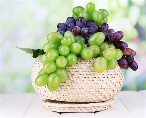 Uvas Verdes E Roxas Maduras Na Cesta Na Mesa De Madeira No Fundo