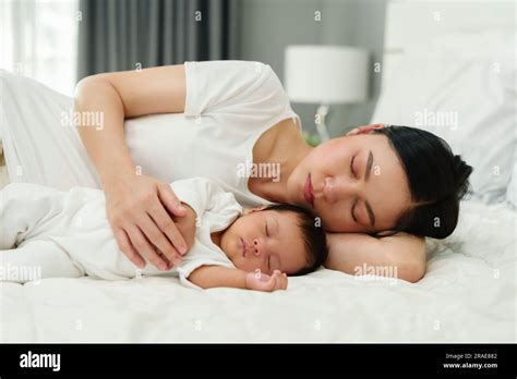 Mother And Her Baby Sleeping Together On A Bed Stock Photo Alamy