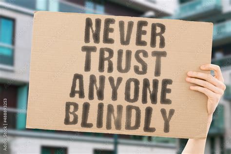 The Phrase Never Trust Anyone Blindly On A Banner In Men S Hand