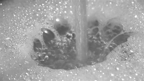 Foam And Soap Bubbles From Water In A Sink With Water Running From A