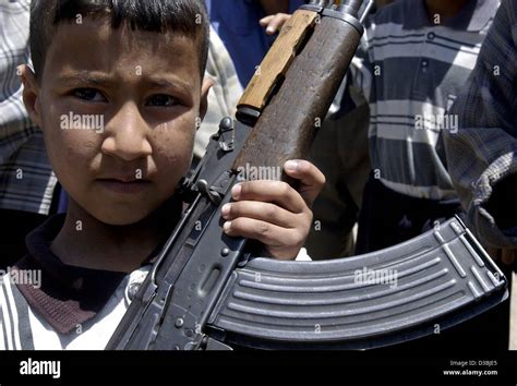 Dpa An Iraqi Boy Holds A Machine Gun At The Weapons Market In Saddam City On The Outskirts