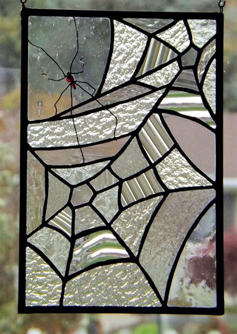 A Close Up Of A Stained Glass Window With Spider Web On Its Side