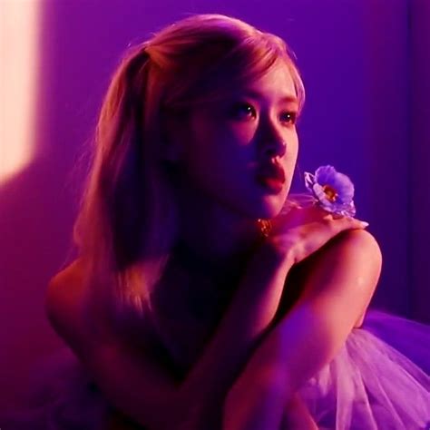 A Woman In A Tutu With A Flower In Her Hand And Purple Light Behind Her