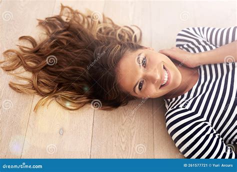 Let it All Hang Out. High Angle Portrait of a Young Woman Lying on Her Living Room Floor. Stock ...