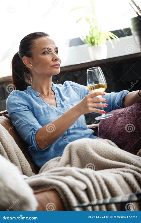 Leisure Time Concept Happy Beautiful Woman Drinks White Wine From Glass Sitting On A Couch