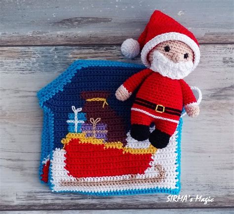 A Crocheted Santa Clause Laying On Top Of A Rug