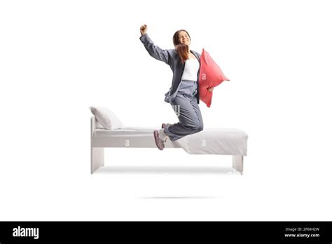 Happy Female In Pajamas Holding A Pillow And Jumping Out Of Bed