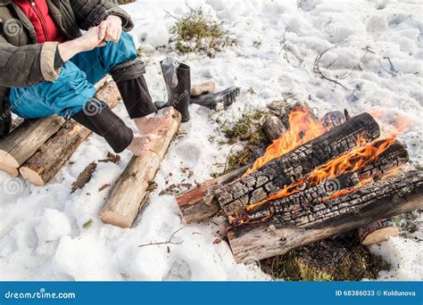 A Man Warms Near The Fire In The Forest Covered With Snow Stock Image