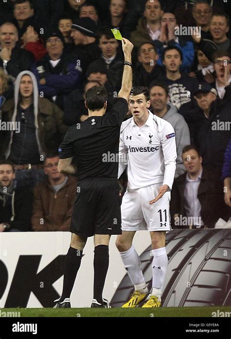 Referee Antonio Miguel Mateu Lahoz Shows The Yellow Card To Tottenham