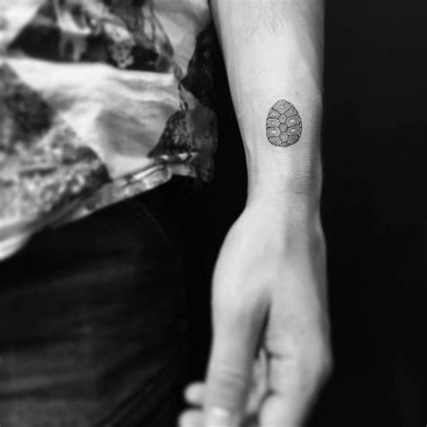 Turtle shell tattoo located on the wrist.