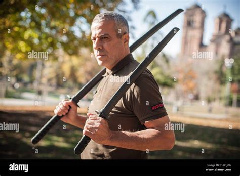 Instructor demonstrates katana sword fighting techniques and training methods in public park ...