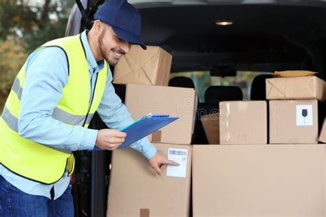 Young Courier Checking Amount Of Parcels In Delivery Van Stock Image