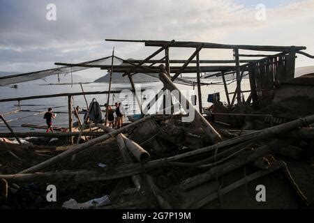 Fishermen Catch Fish As The Taal Volcano Releases Smoke And Ash In