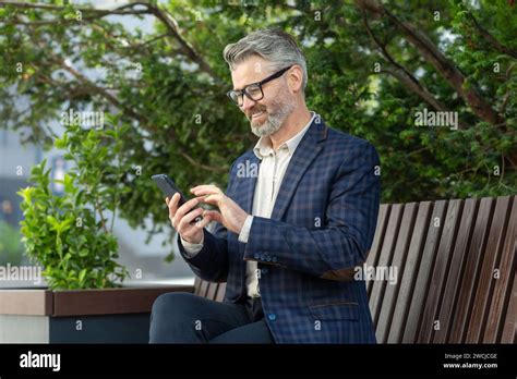 Mature Corporate Professional In A Suit Engaged With His Smartphone