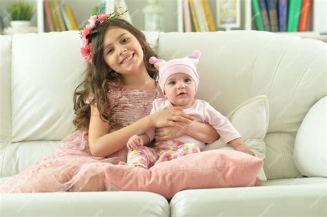 Premium Photo Portrait Of Two Beautiful Cute Sisters Posing In Sofa