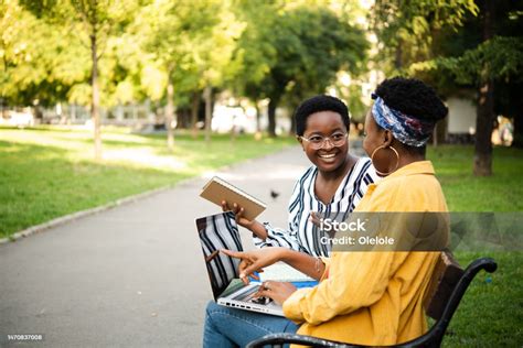 Two African American Girls Sitting In The Park And Learning Together