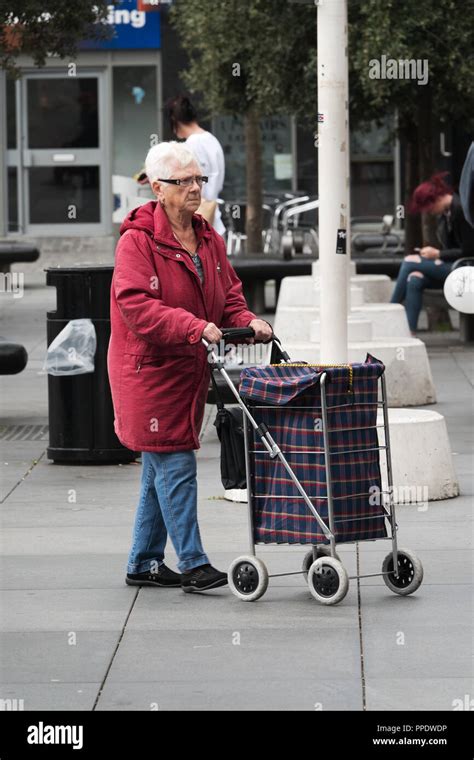 An Elderly Woman Pushing A 4 Wheel Shopping Trolley Stock Photo Alamy