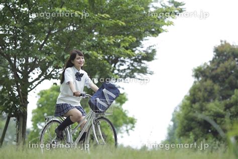 新緑の中の自転車に乗る女子高生の写真素材 9971807 イメージマート