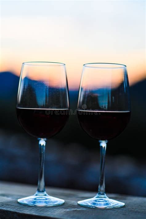 Two Glasses Of Wine At Sunset Dramatic Sky On Mountain Landscape