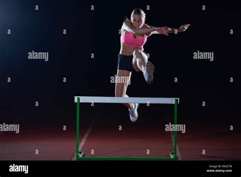 Woman Athlete Jumping Over A Hurdles Stock Photo Alamy