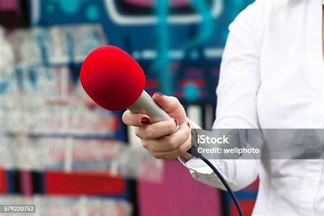 Periodista Sosteniendo Un Micrófono Conduciendo Una Entrevista De Radio