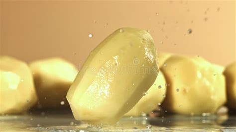 Peeled Potatoes Fall On A Wet Table Filmed On A High Speed Camera At