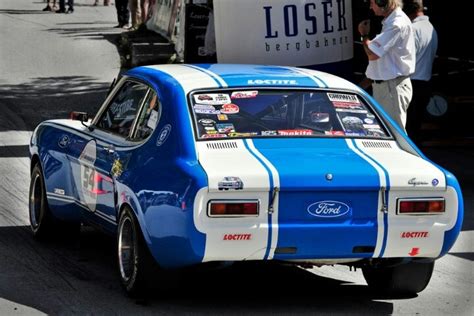 A Blue And White Race Car Driving Down The Street