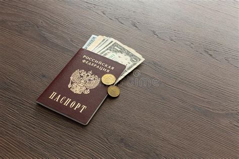 On The Table There Is A Russian Passport Inside Various Dollar Bills