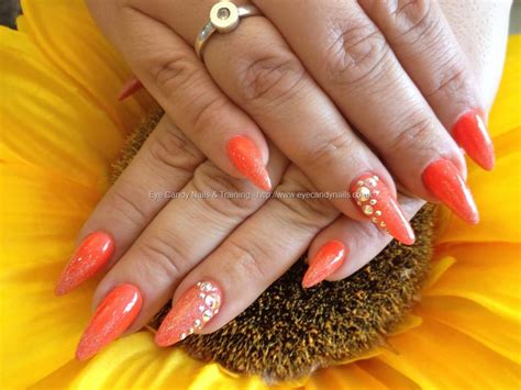 Stiletto Nails With Orange Gel Polish And Swarovski Crystals On Ring