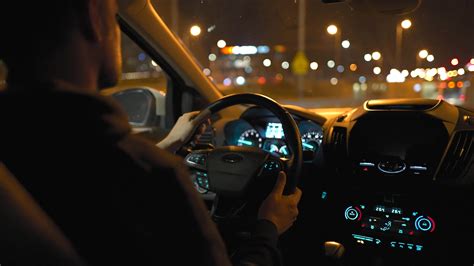 Man Driving Car Through The Streets Of Night City View From The Back