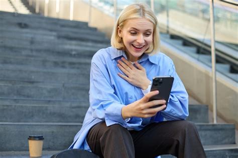 Portrait d une jeune femme blonde assise à l extérieur du campus sur les escaliers de la ville
