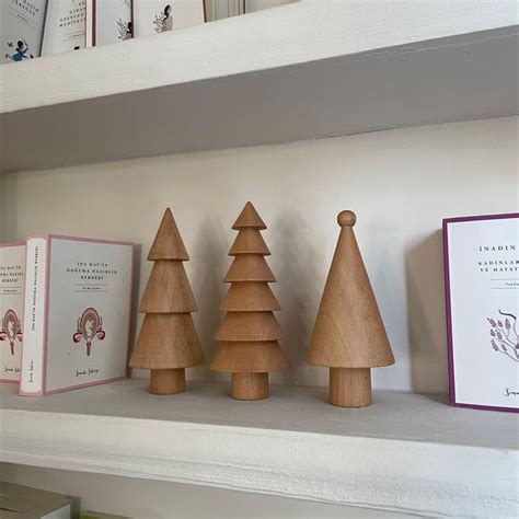 Three Wooden Christmas Trees Sitting On Top Of A White Shelf Next To