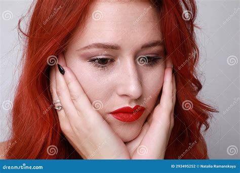 Thougtful Young Woman With Long Red Hair Posing On White Background