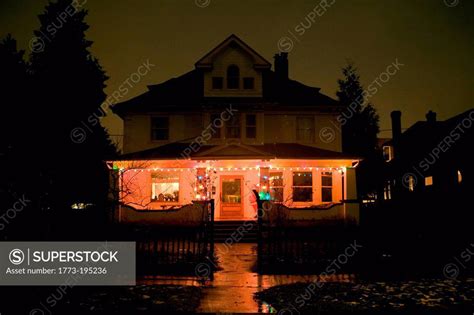 Christmas lights on house at night - SuperStock