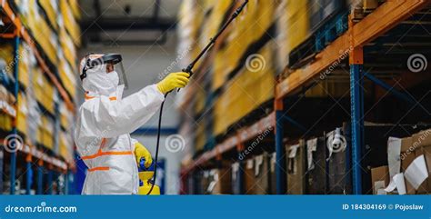 Man Worker With Protective Mask And Suit Disinfecting Industrial