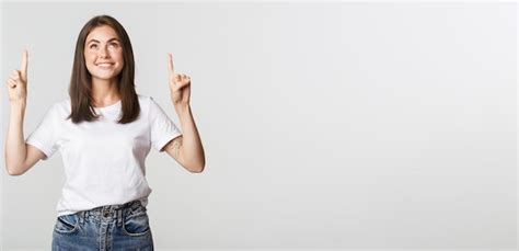 Premium Photo Attractive Smiling Brunette Girl Pointing Fingers Up