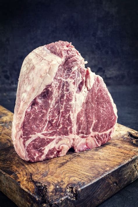 Traditional Raw Dry Aged Wagyu Porterhouse Steak On An Old Rustic Board Vintage Stock Image