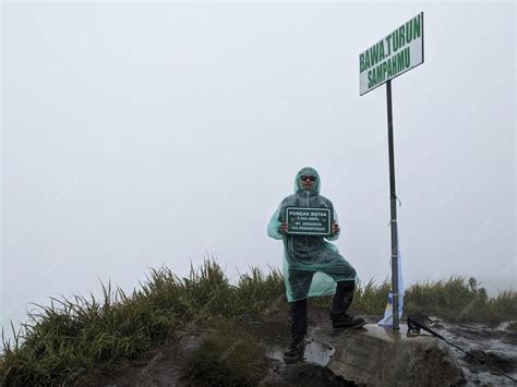Premium Photo | Man reach peak of mountain when rainy day with foggy vibes