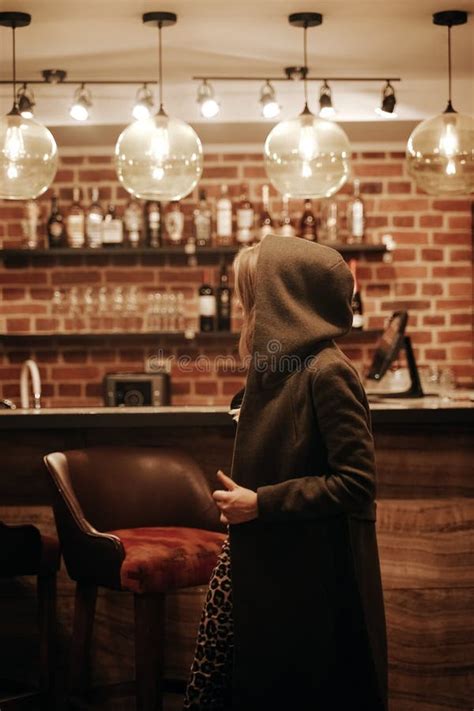 Beauty Young Woman In Hooded Coat Portrait At A Night Bar Alone Stock