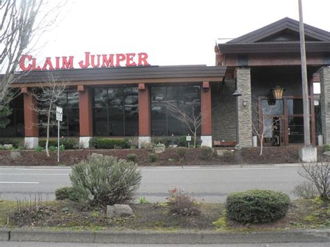 The Front Of A Chain Jumper Restaurant With Trees And Bushes Around It