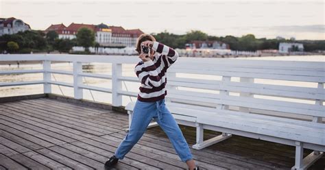 Un Portrait De Préadolescente Prenant Une Photo Avec Un Appareil Photo Sur La Jetée Par La Mer