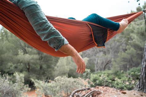 Premium Photo Man Relaxing On Hammock Against Trees