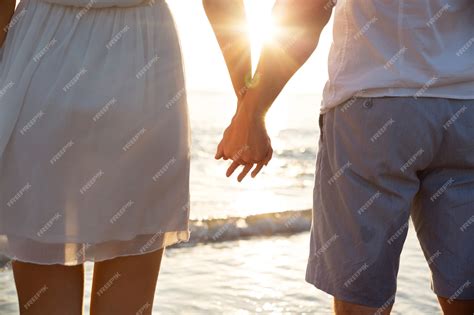 Premium Photo Summer Couple Holding Hands At Sunset On Beach