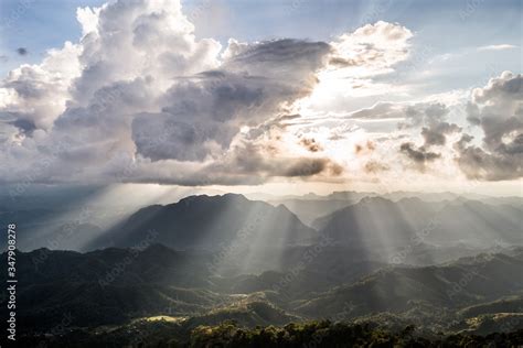 Golden Light Rays From Clouds Shining Down To Mountains Sun Rays Over