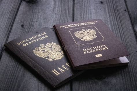 Two Passports Of The Russian Federation Lie On A Rough Wooden Surface